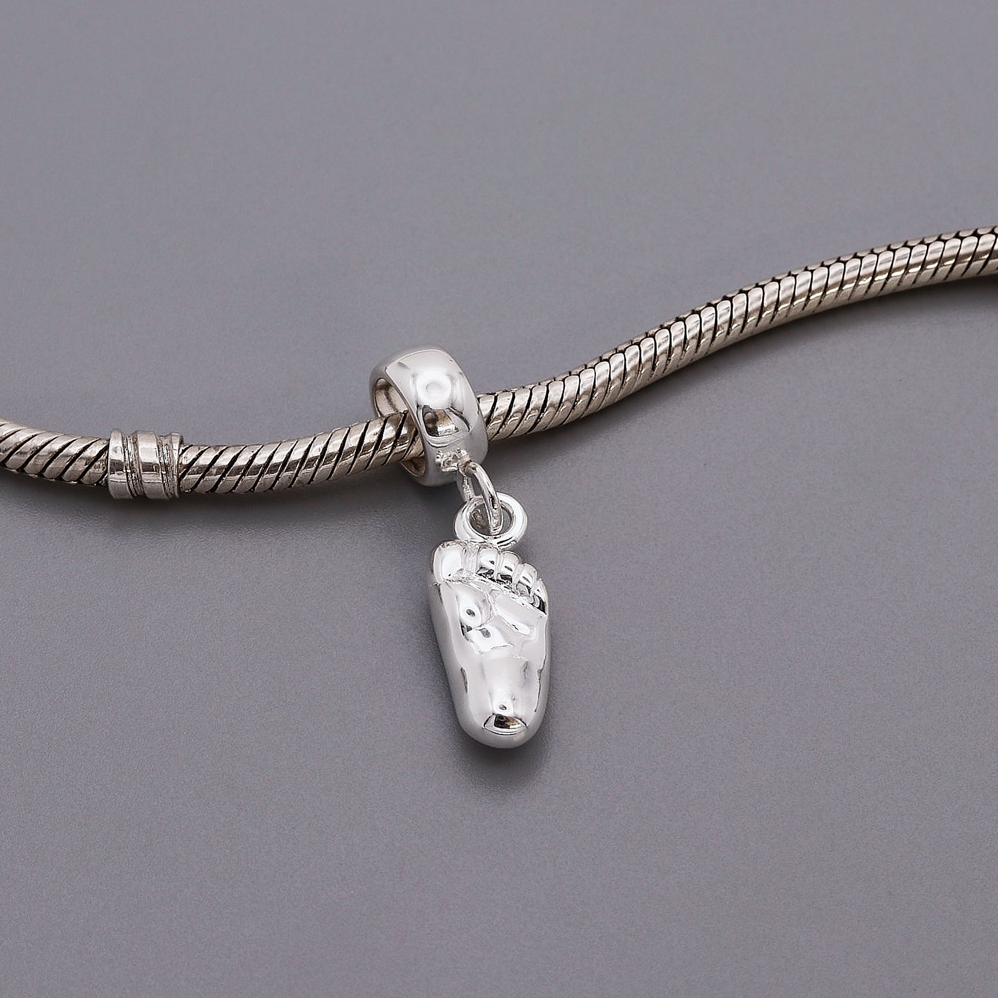 silver baby foot charm with charm carrier on bracelet