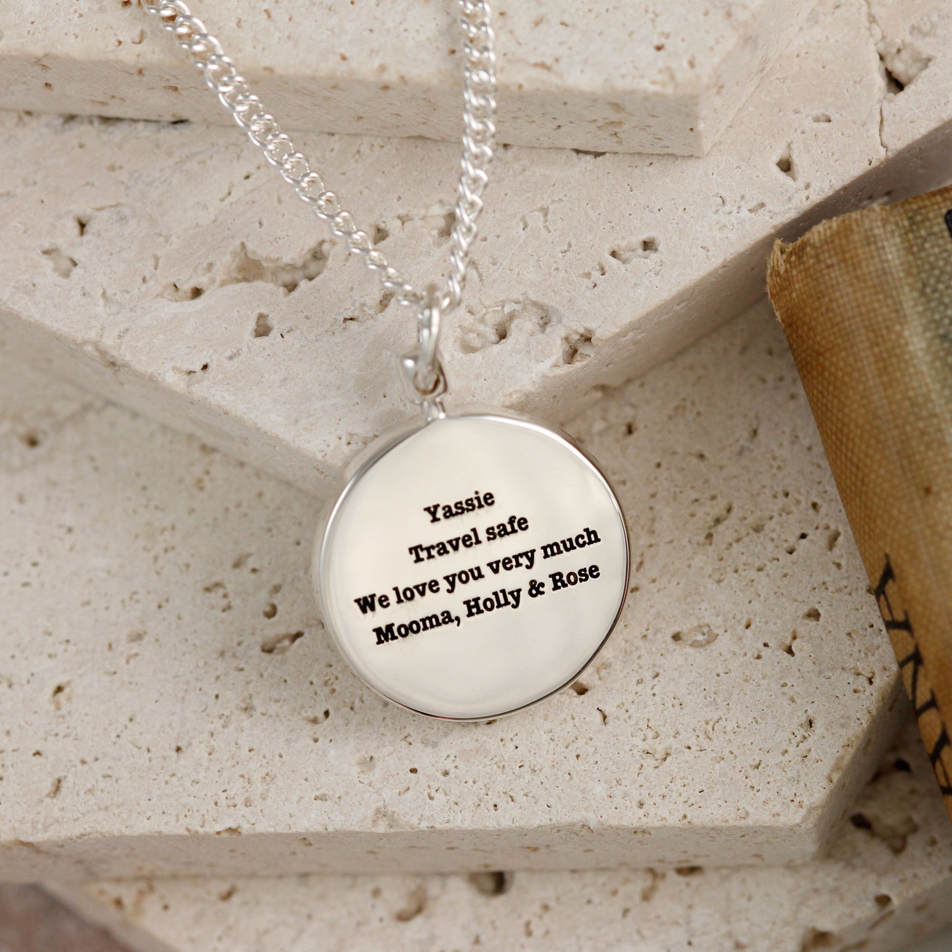 engraved back of silver globe necklace