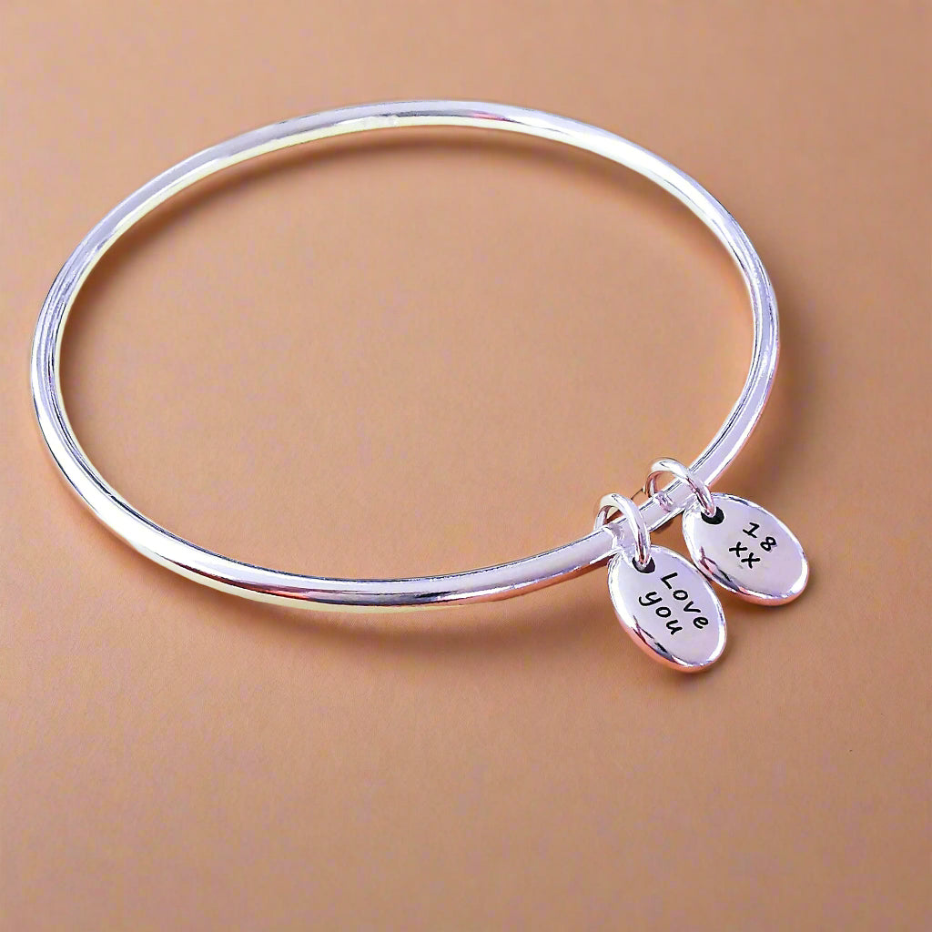 silver bangle with two personalised silver pebble charms for 18th birthday gift