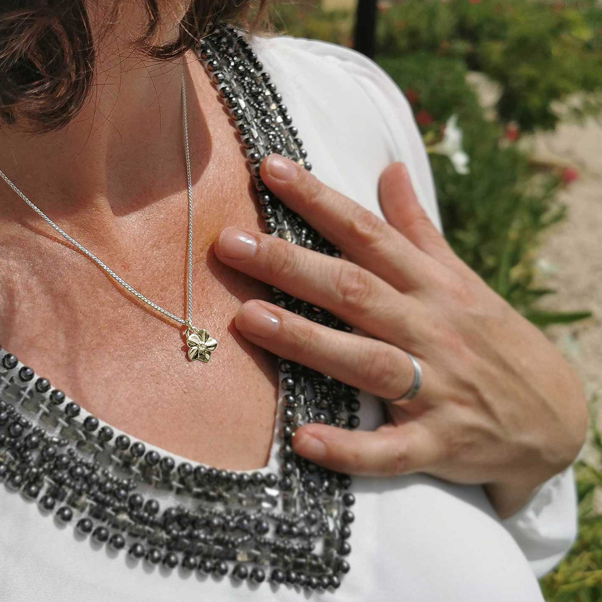 Solid gold forget-me-not flower necklace on silver chain designer Scarlett Jewellery Chelsea Flower Show