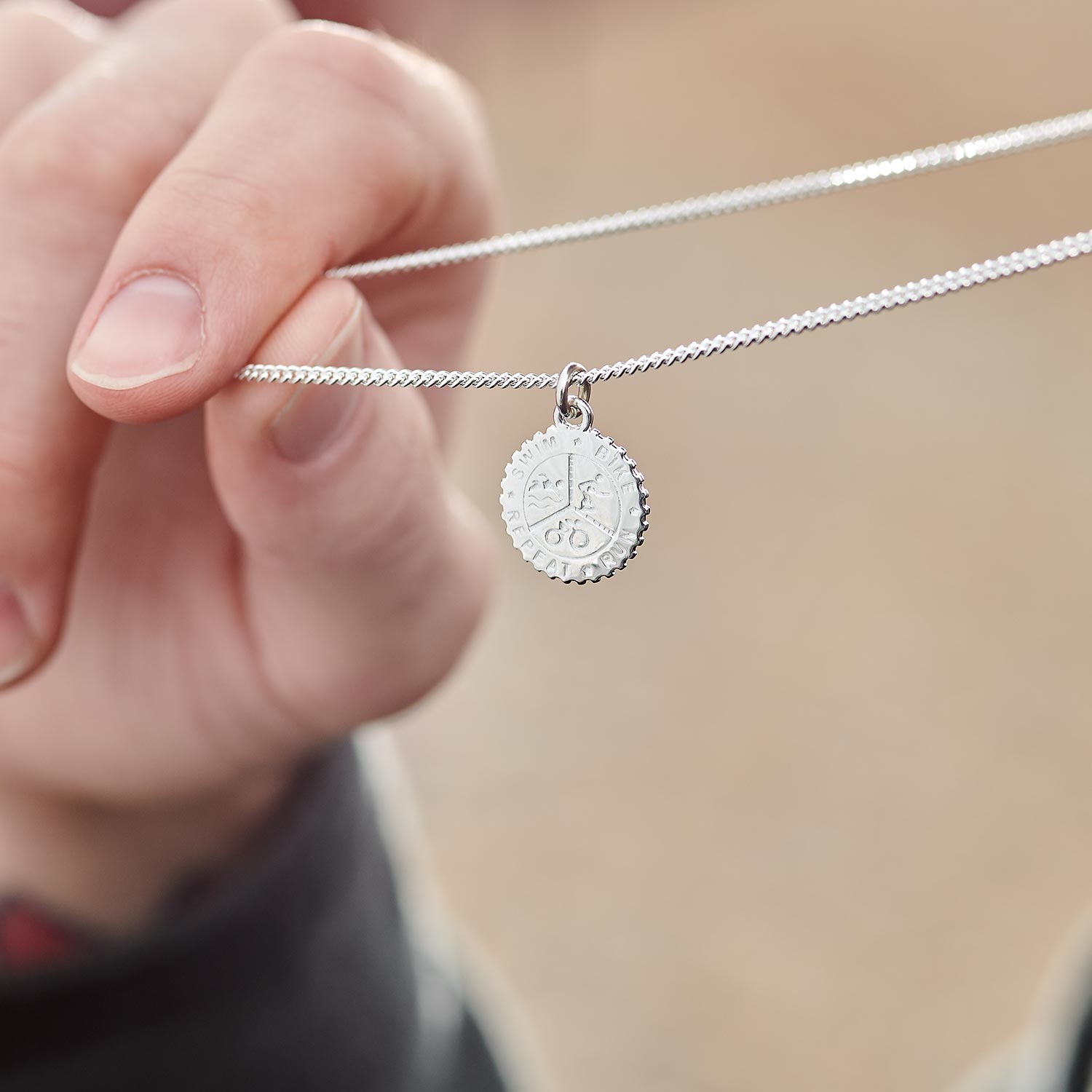 Men's and women's silver triathlon pendant necklace 'swim bike run repeat'