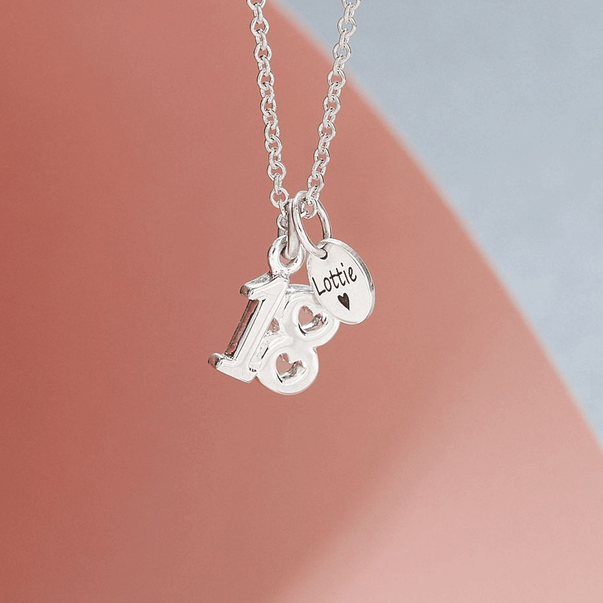 Silver 18th birthday necklace with 'Lottie' pendant on a soft pink background