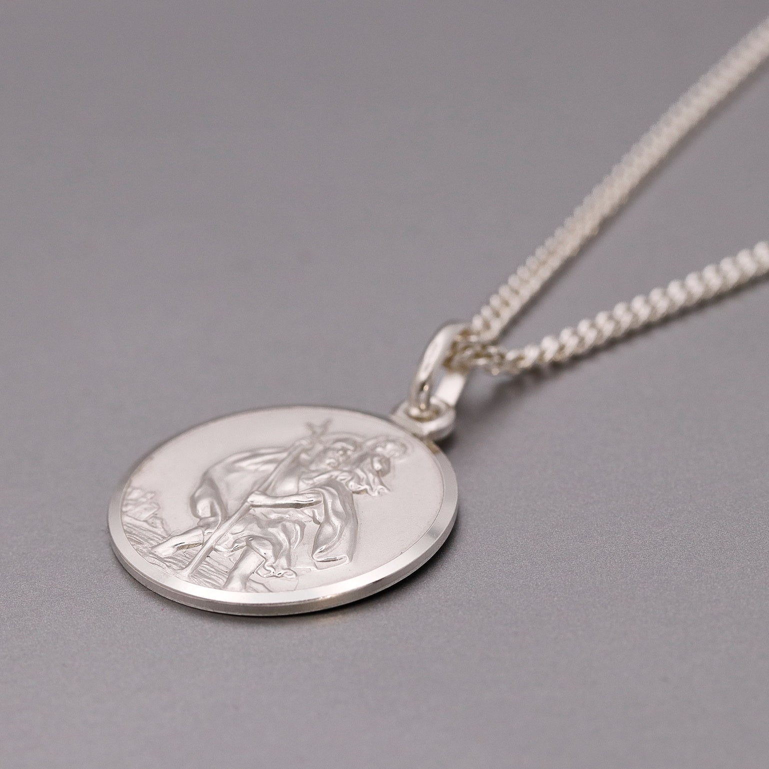 Silver pendant necklace on a gray background