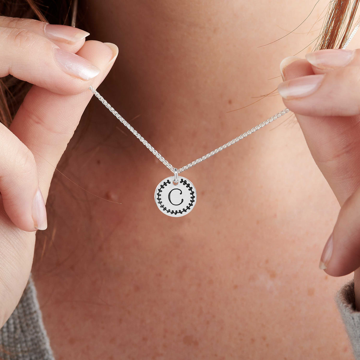 initial silver disc necklace with leaf border design