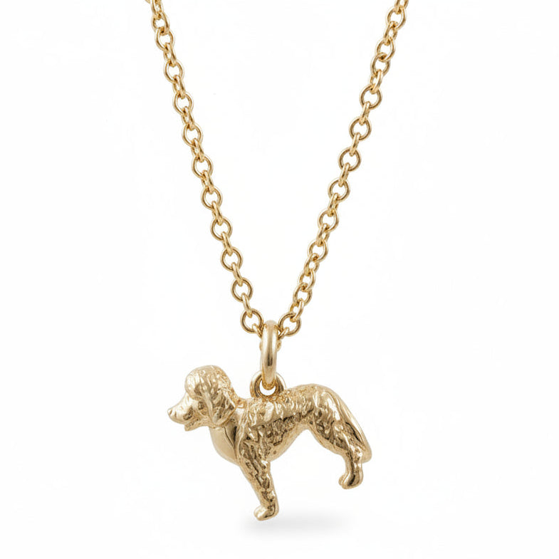 Gold dog-shaped pendant on a chain against a gray background