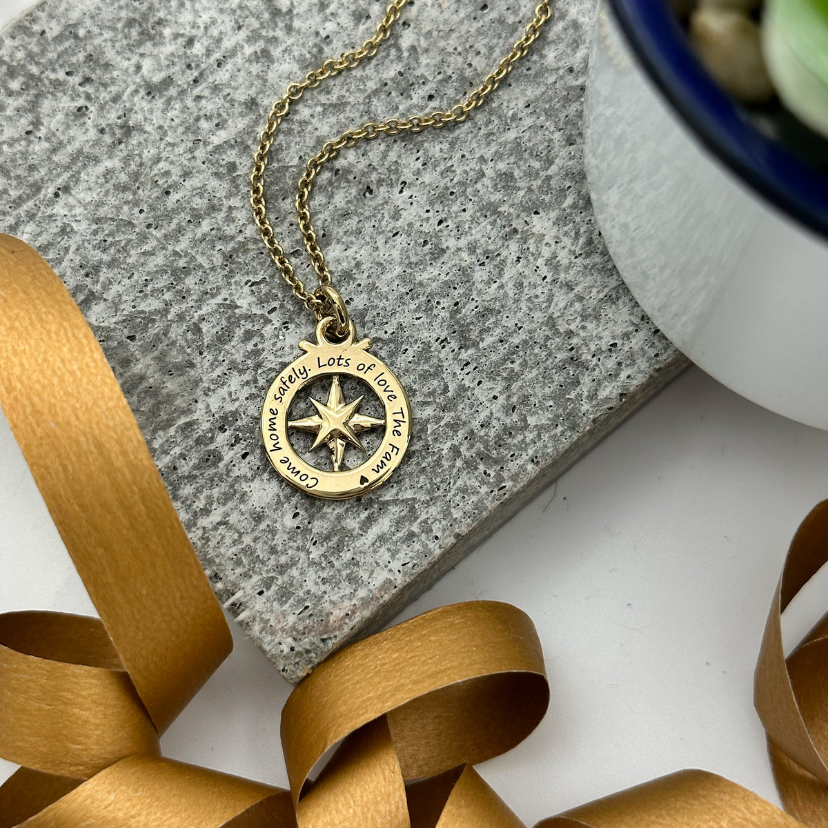 engraved back of gold plated outline compass necklace on trace chain