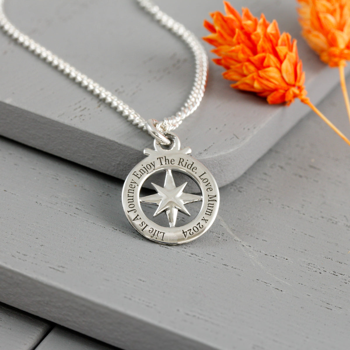 engraved good luck message on back of small compass necklace