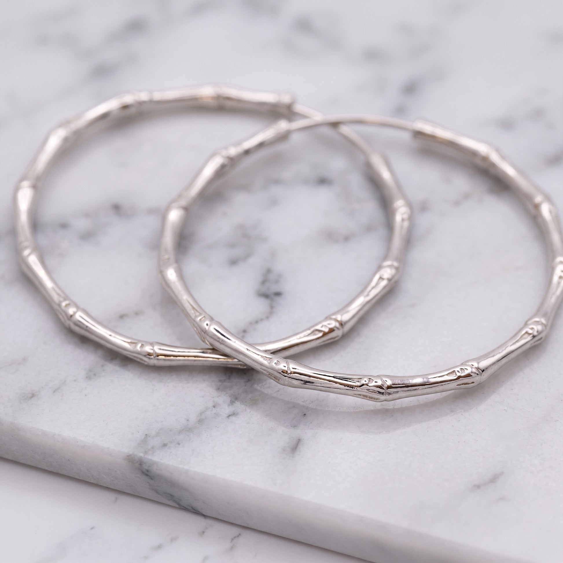 Silver hoop earrings on a marble surface