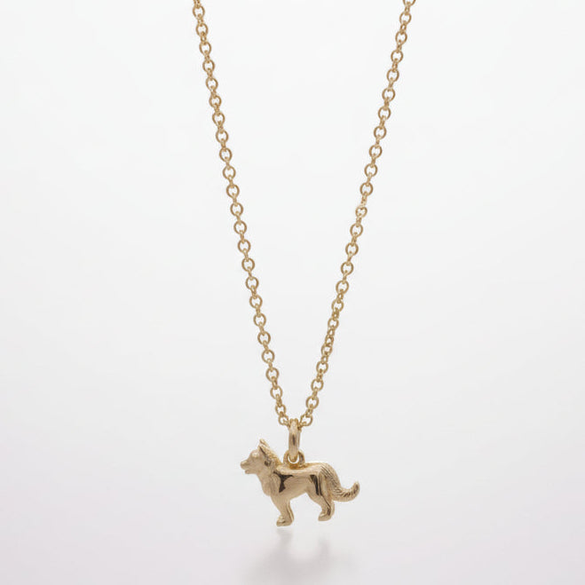 Gold dog-shaped pendant on a thin chain against a white background