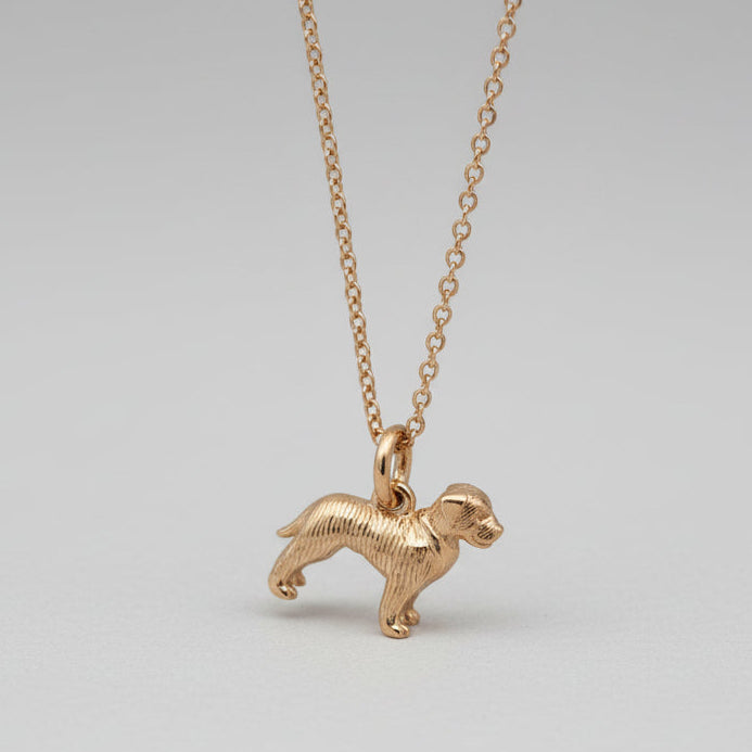Gold dog-shaped pendant on a chain against a white background
