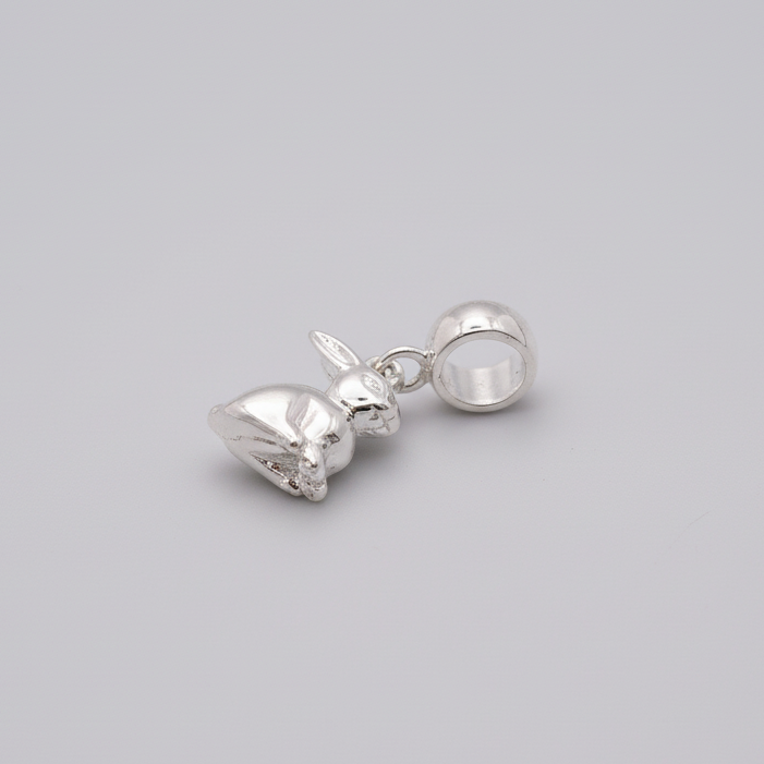 Silver earring with a small round gemstone on a gray background