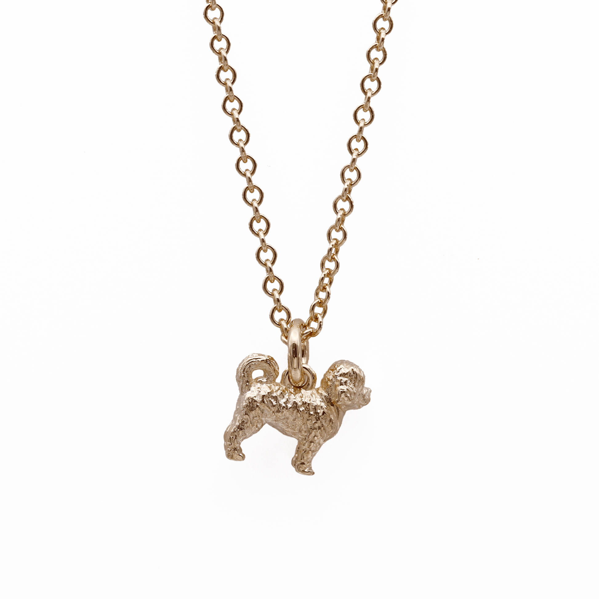 Gold dog-shaped cavapoo pendant on a chain against a white background