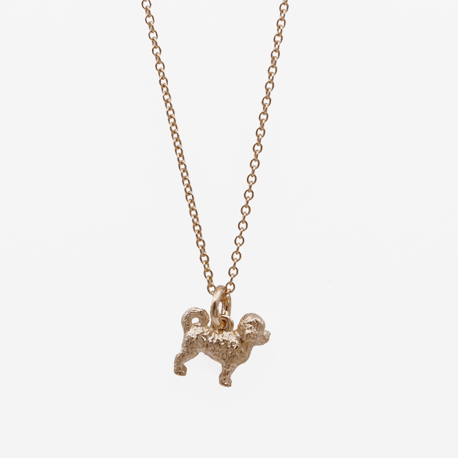 Gold cavapoo dog-shaped pendant necklace on a white background