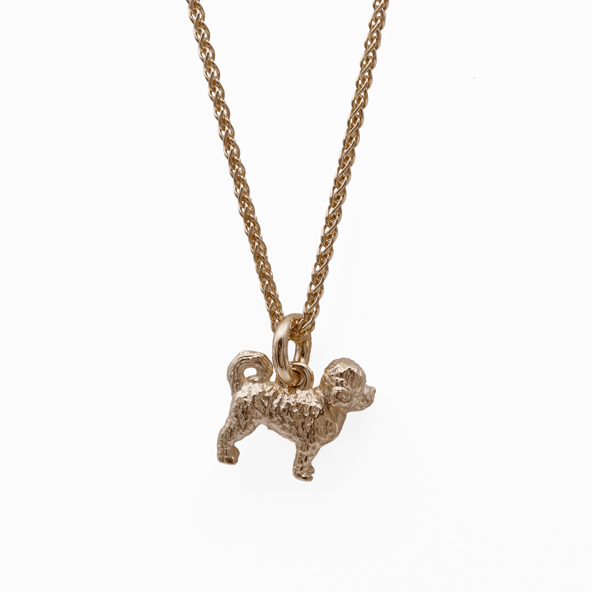 Gold cavapoo dog-shaped pendant on a chain against a white background