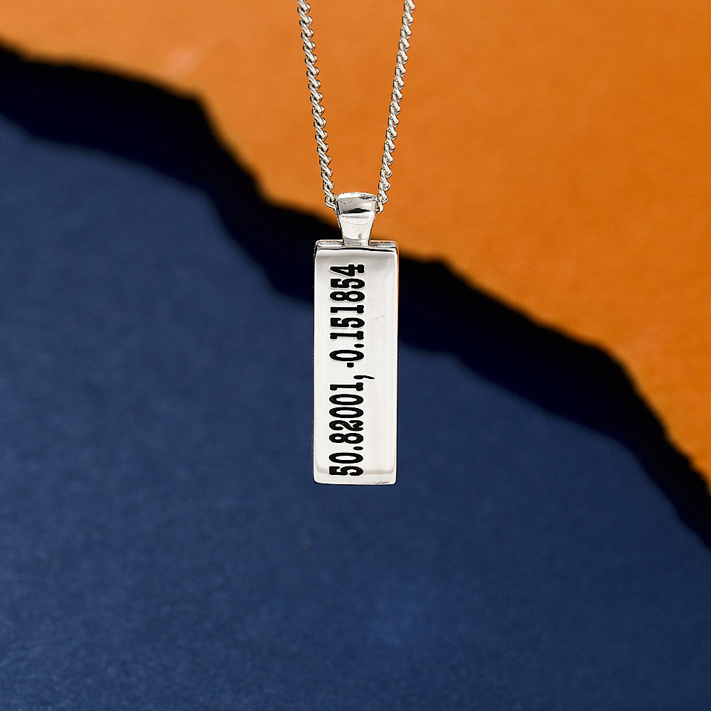 Silver co-ordinates necklace with a rectangular pendant on an orange and blue gradient background