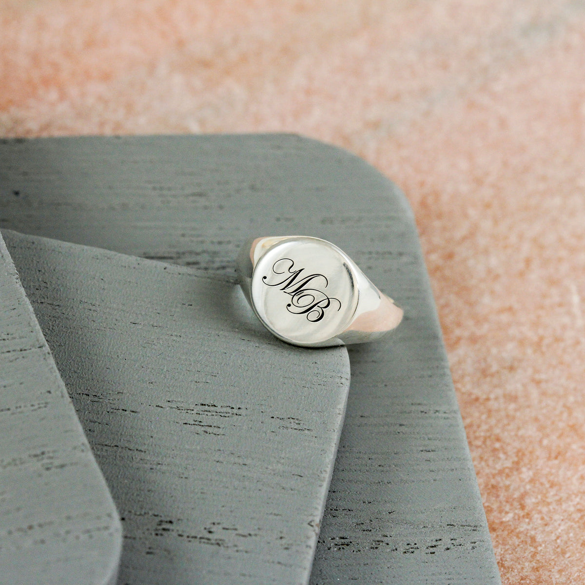 silver round faced signet ring engraved with initials M and B