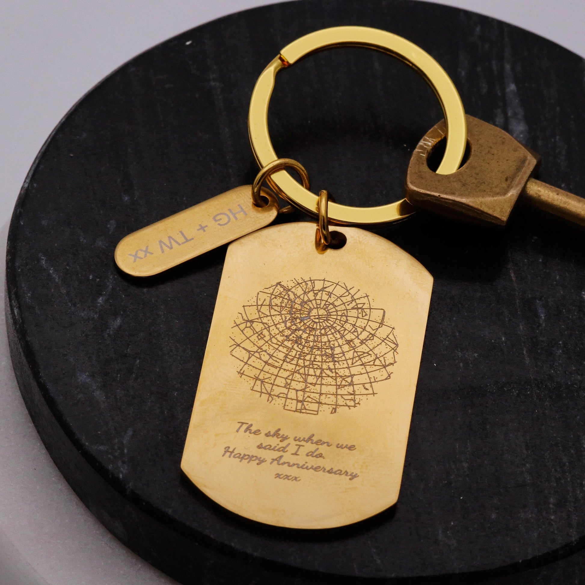Gold keychain with engraved tag on a black surface