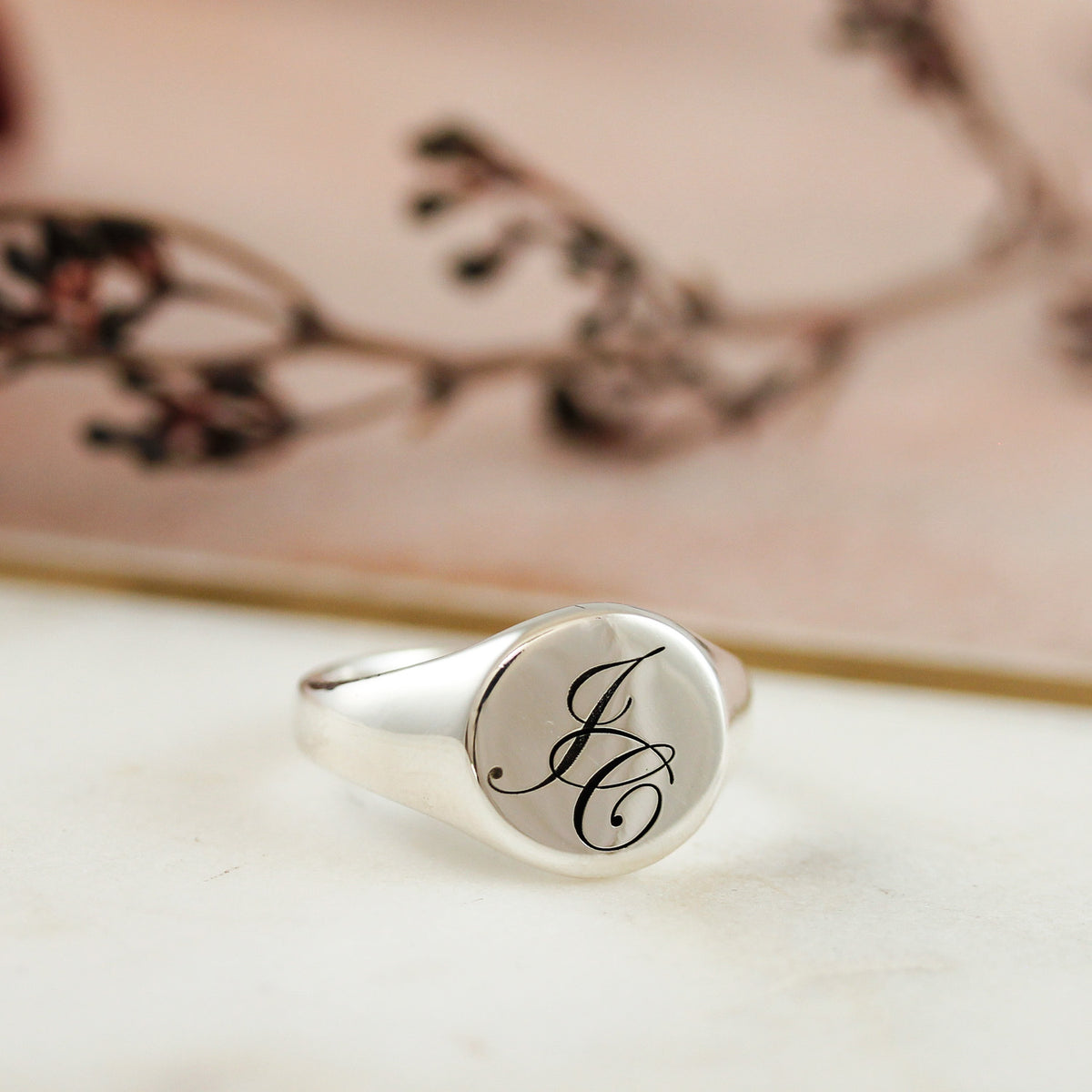 silver mans signet ring engraved with initials JC in a script font