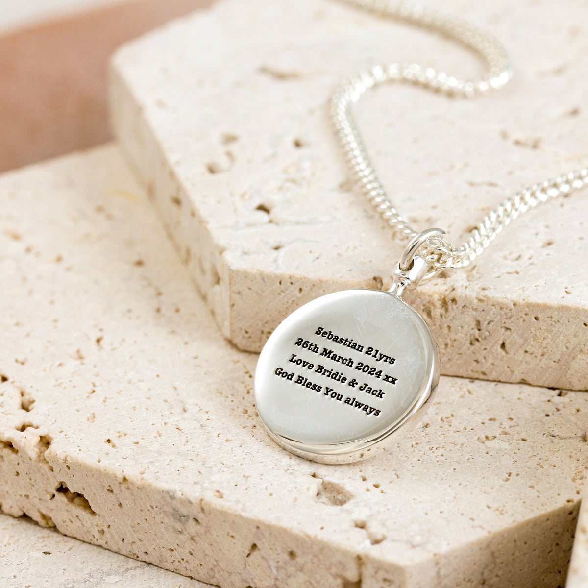 typewriter font engraved back of chunky solid silver world map necklace on heavier curb chain