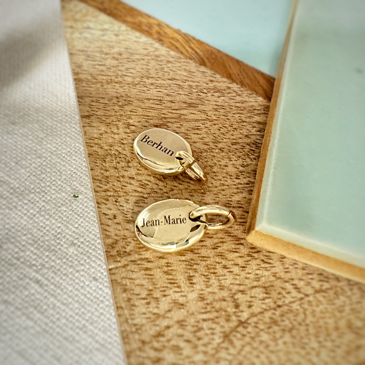 solid gold pebble charms engraved with names