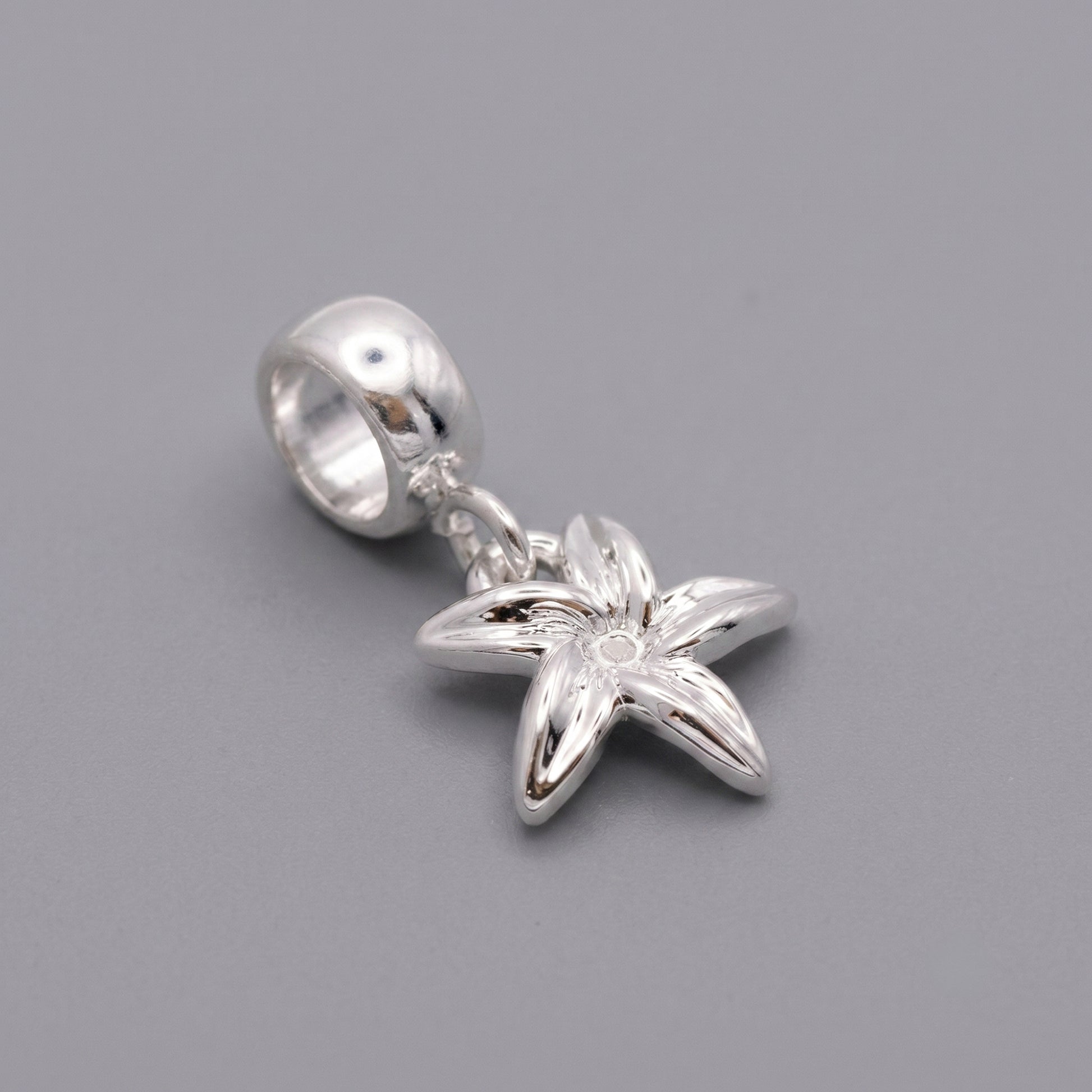 Silver flower pendant on a gray background