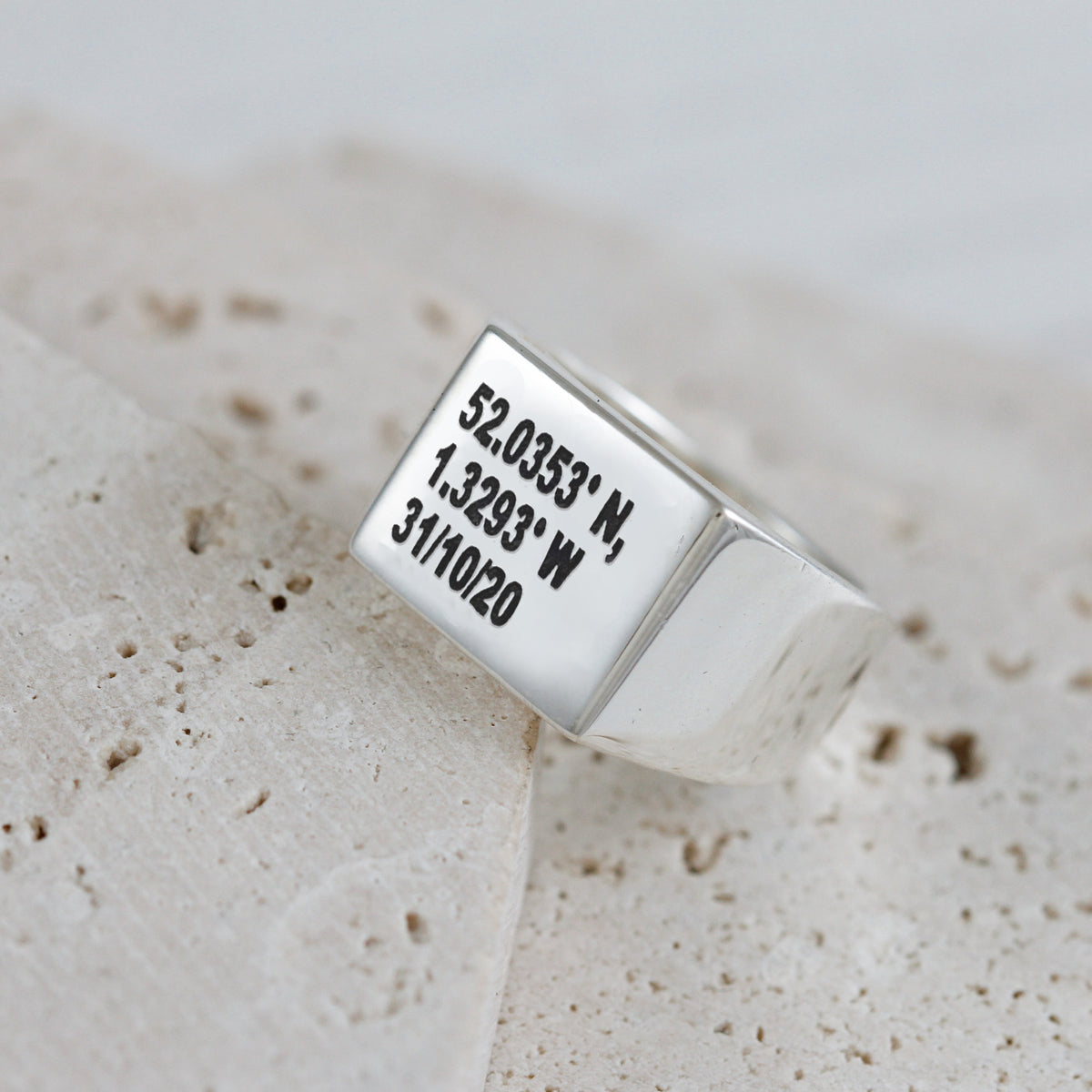 large square signet ring with latitude longitude coordinates and a date engraved