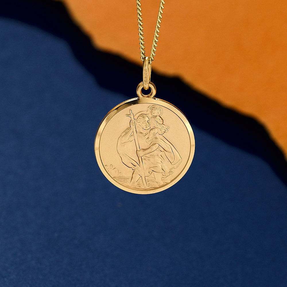 Gold pendant necklace with a saint christopher on light curb chain