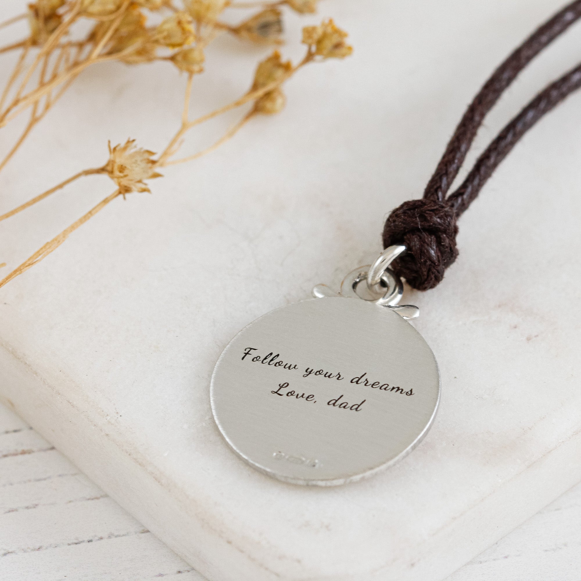 back of matte finish engraved compass necklace with vegan brown cord
