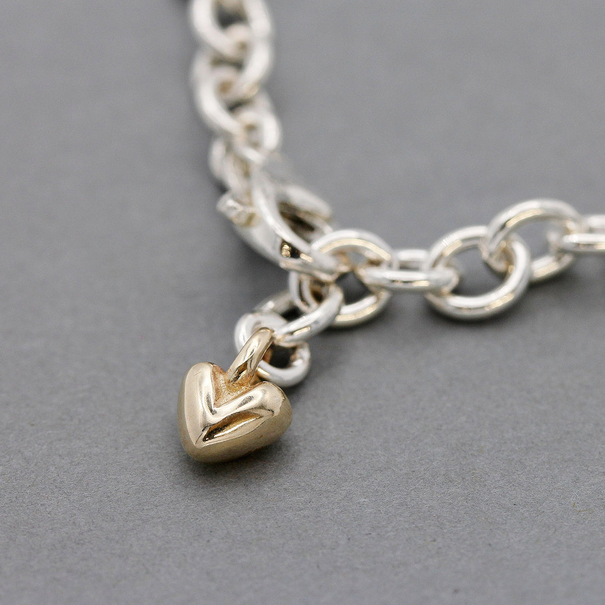 silver adjustable charm bracelet with solid recycled gold heart detail