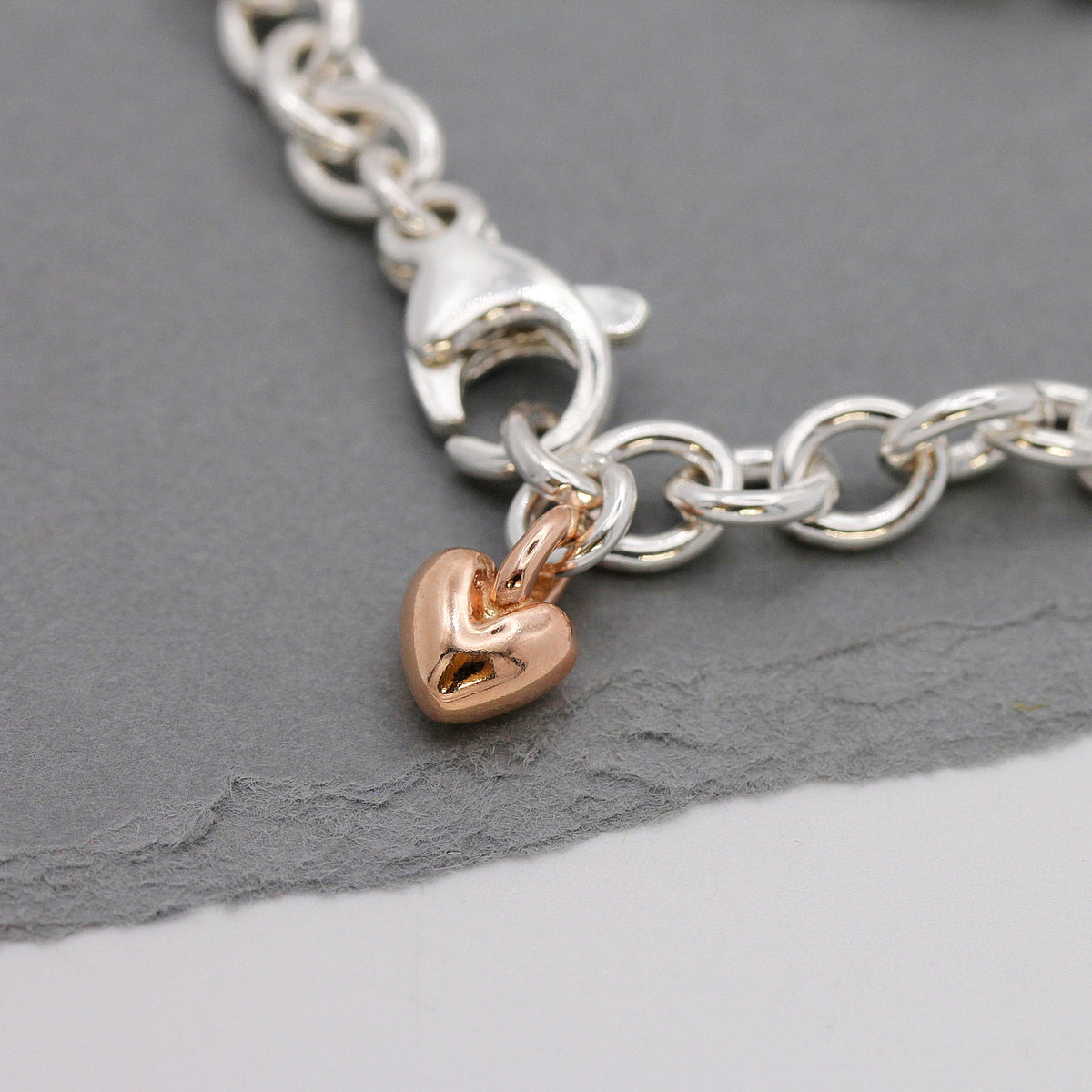 silver adjustable charm bracelet with solid rose gold heart detail