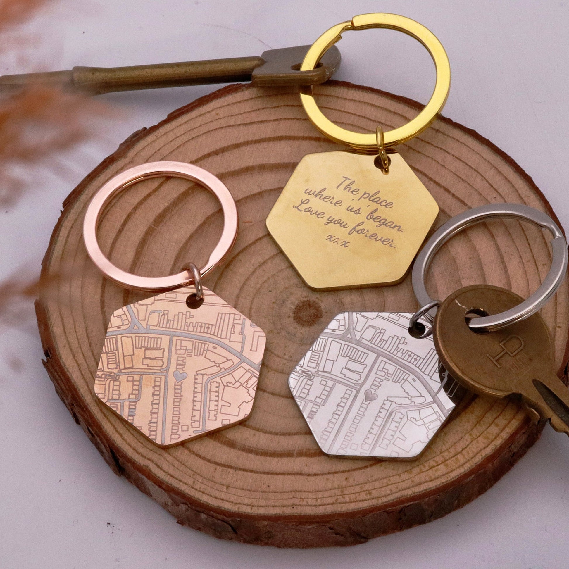 Four keychains with different designs on a wooden surface