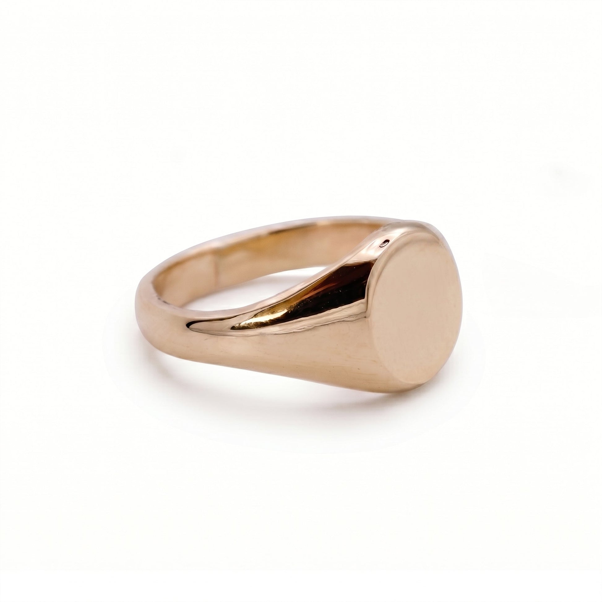 solid gold signet ring on white background
