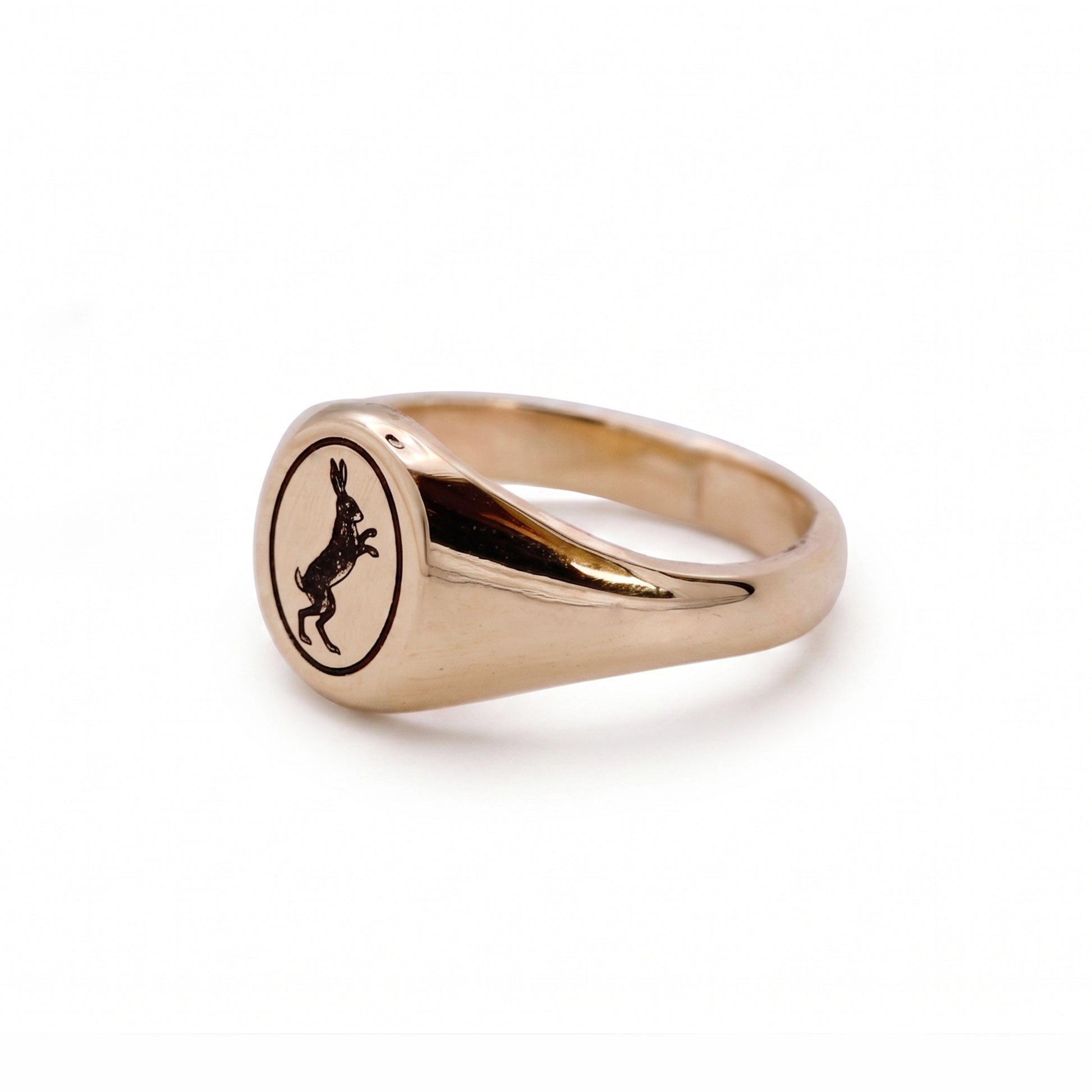 Gold ring with a black engraved design on a white background