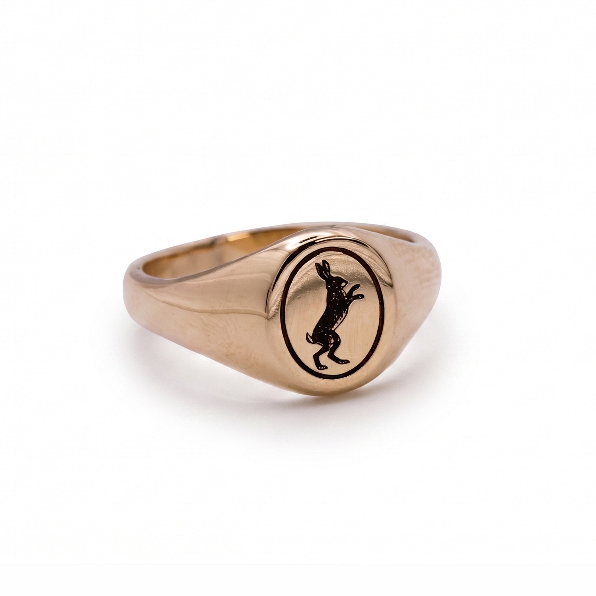 Gold ring with a black engraved design on a white background