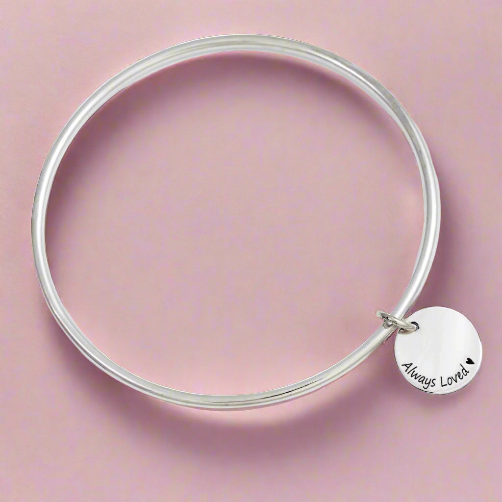 silver disc charm bangle with engraving on a curve