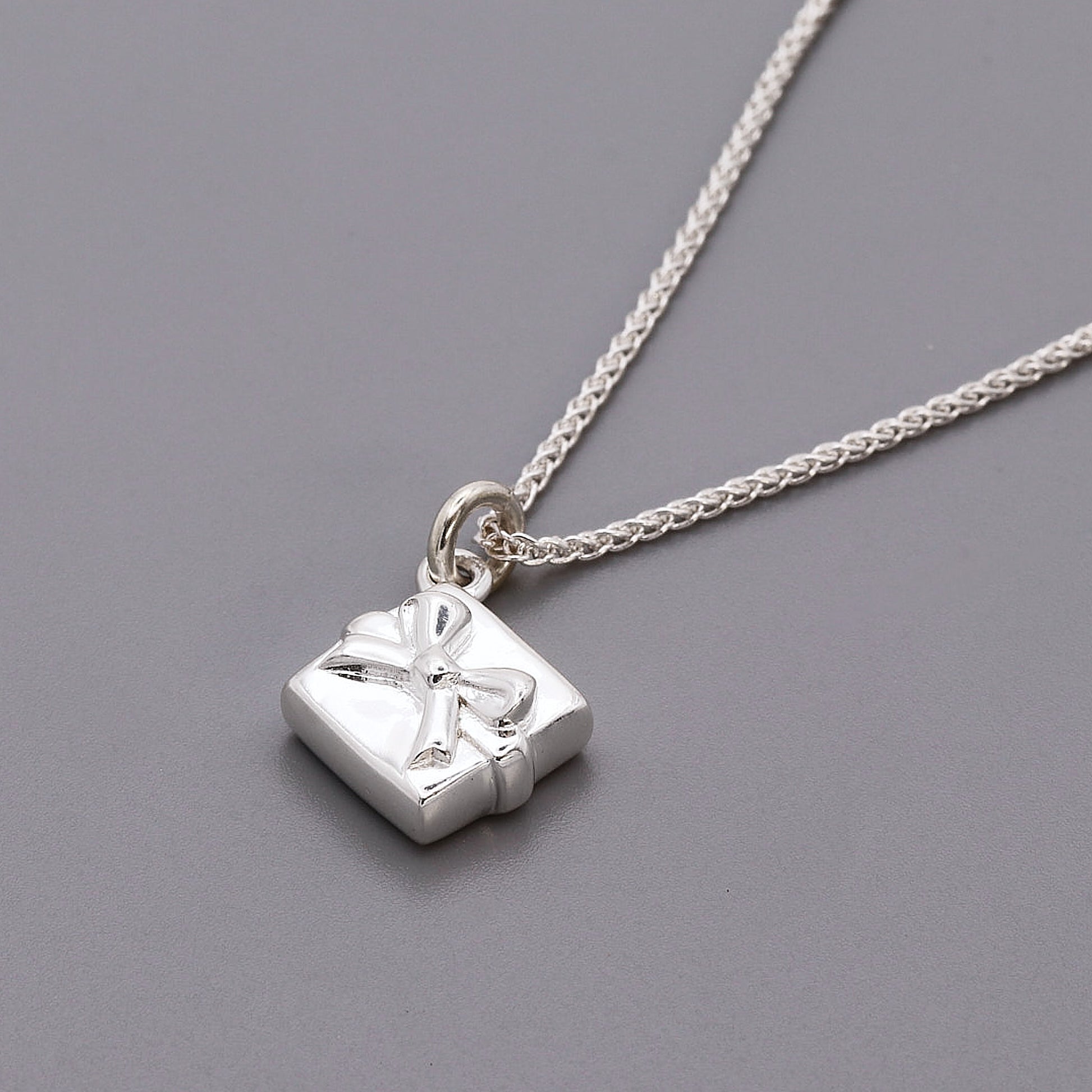 silver present with bow charm with necklace chain