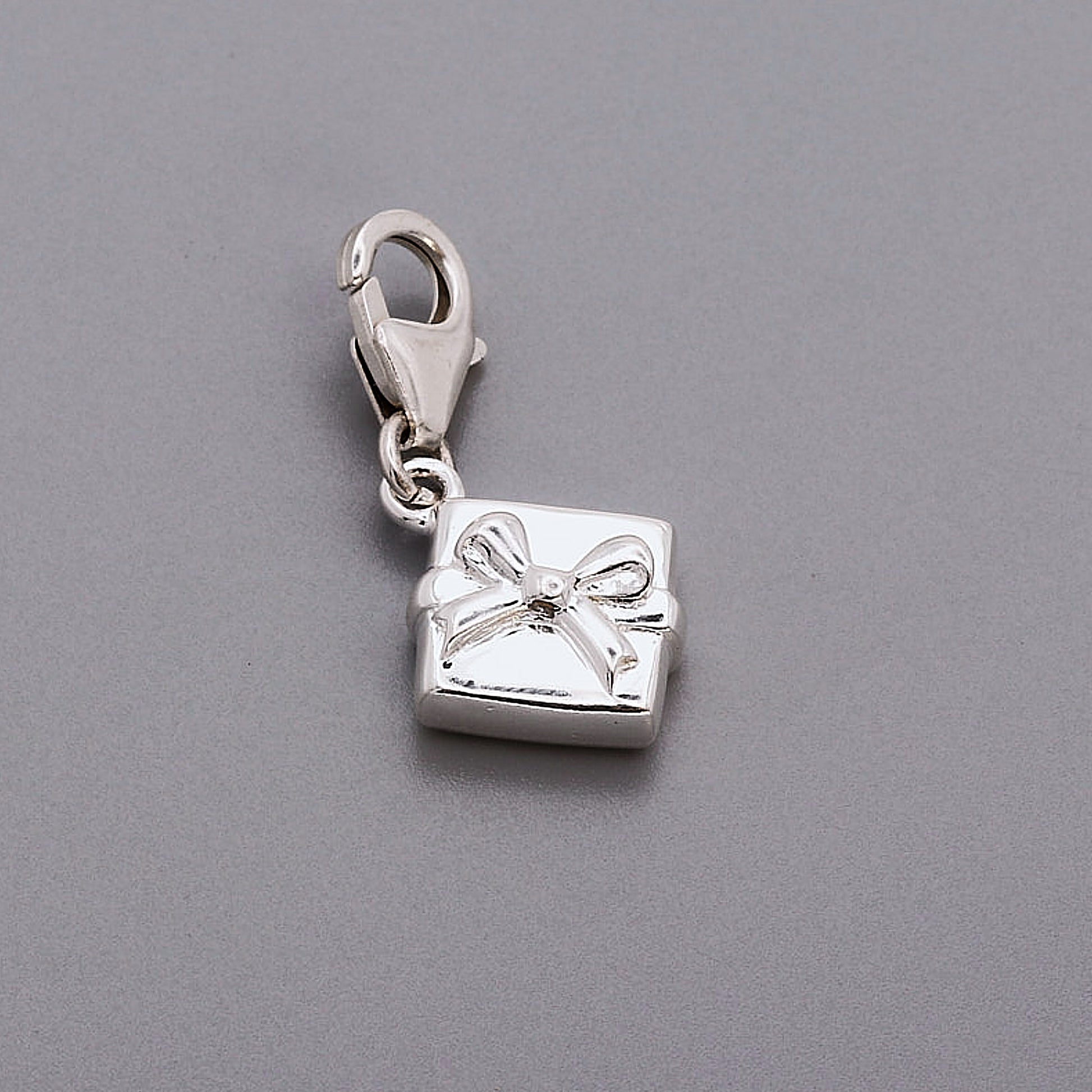 silver present with bow charm with clip on clasp