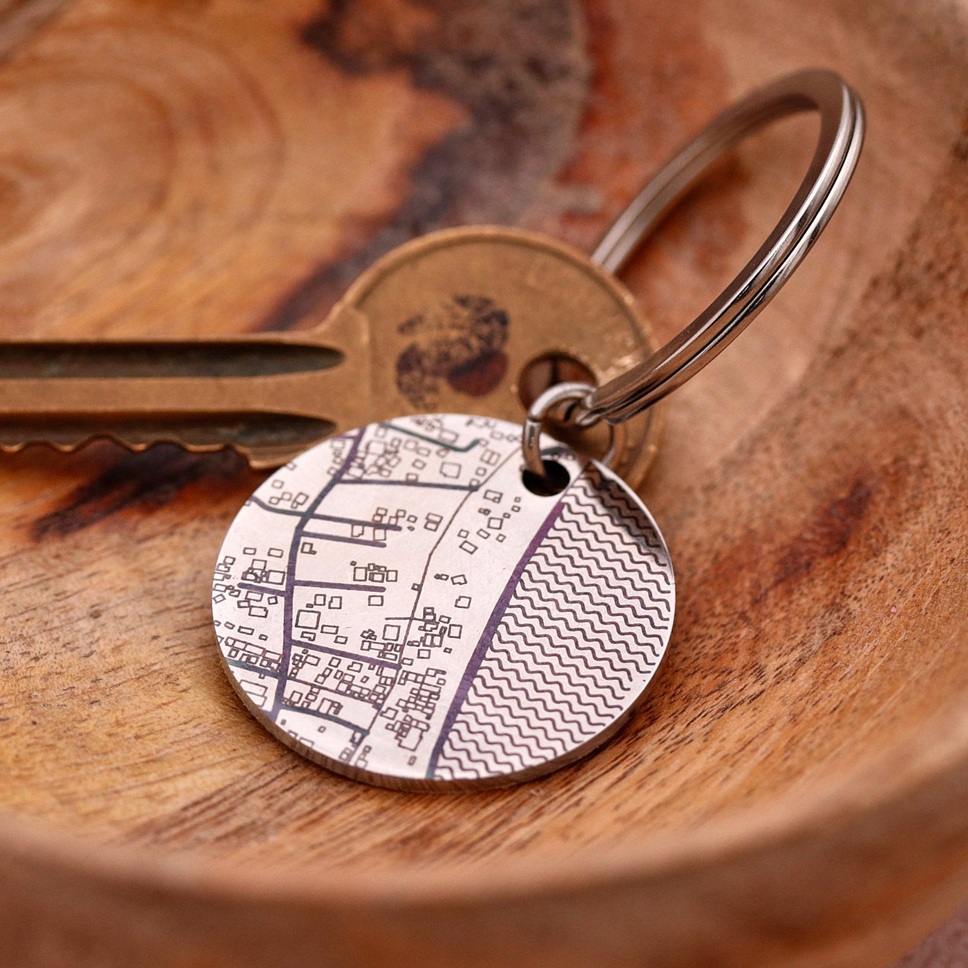 Keychain with a circular metal tag on a wooden surface