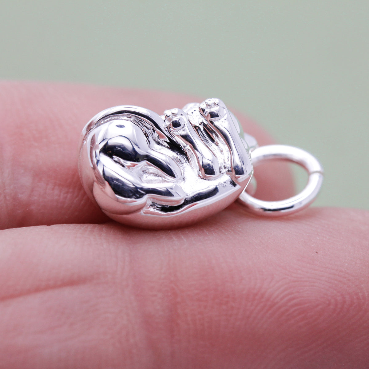 Close-up of sterling silver cat charm with tiny paws detail