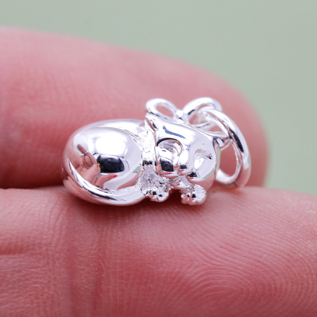 Close-up of sterling silver cat charm with sleeping eyes