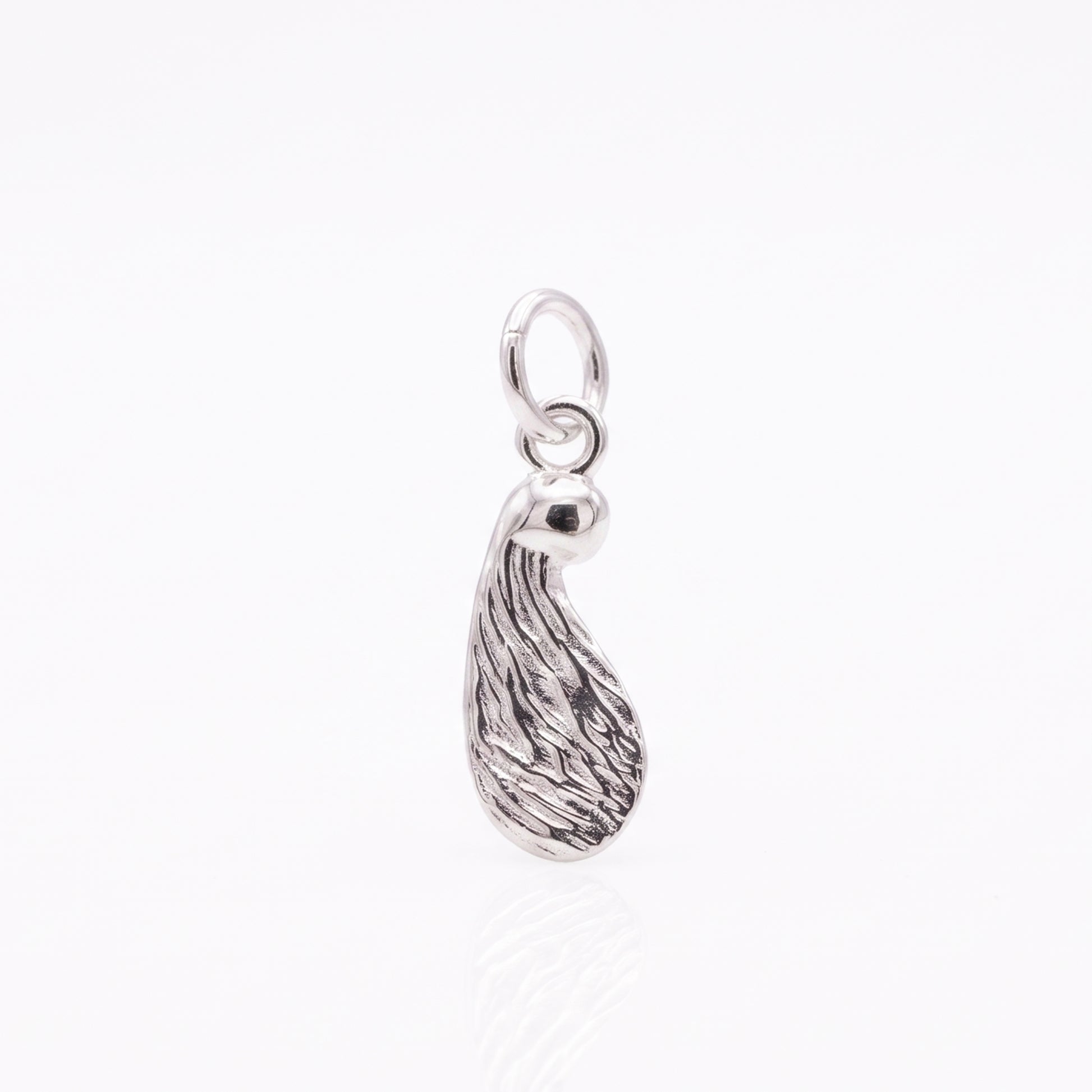 Silver seed-shaped pendant on a white background