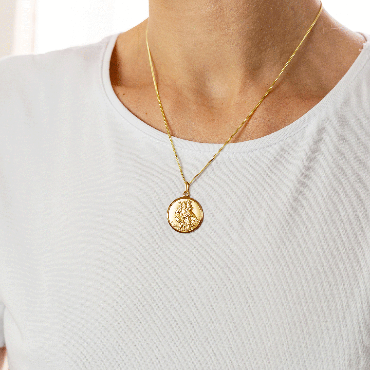 Gold pendant necklace with a saint christopher on light curb chain