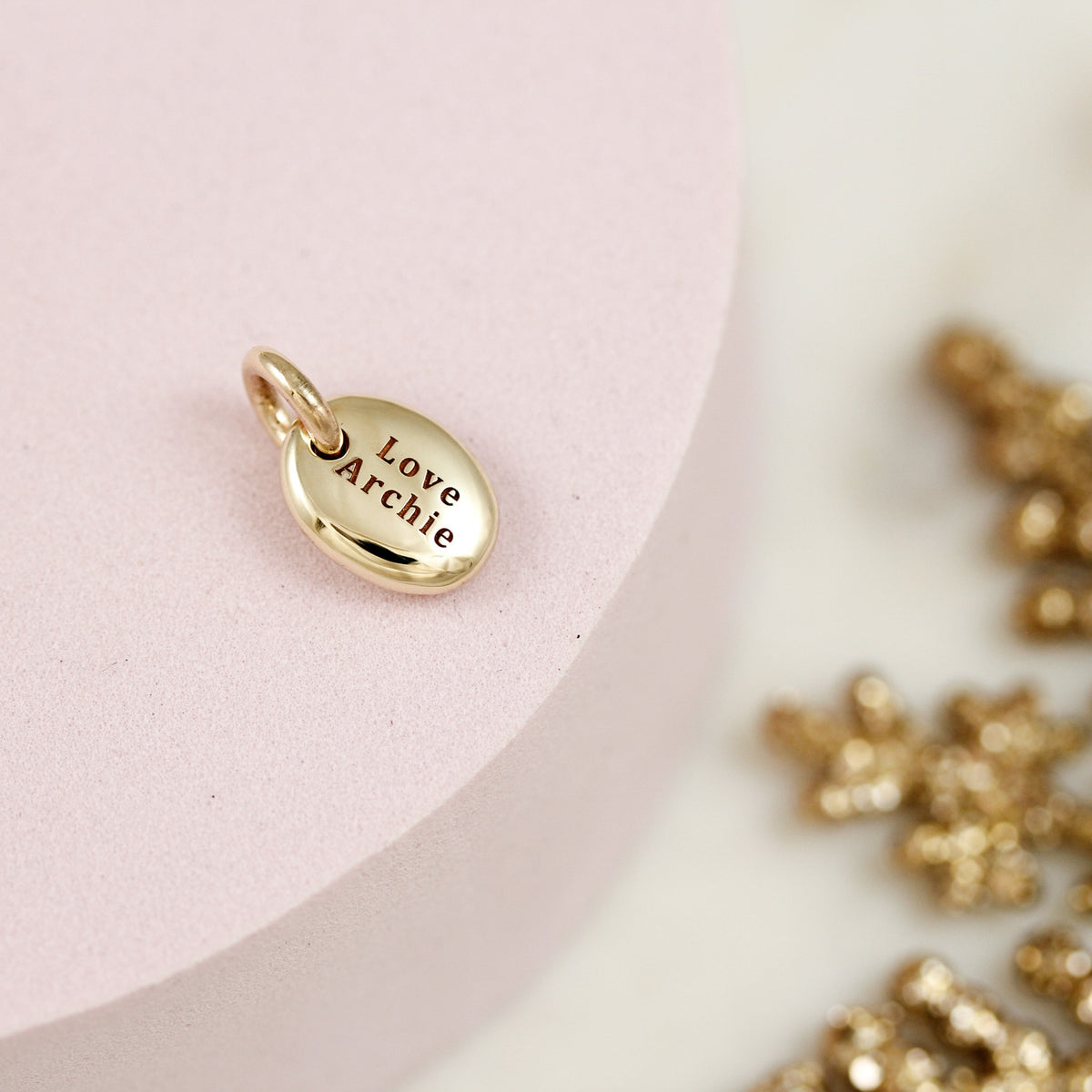 solid gold pebble charm with engraved name