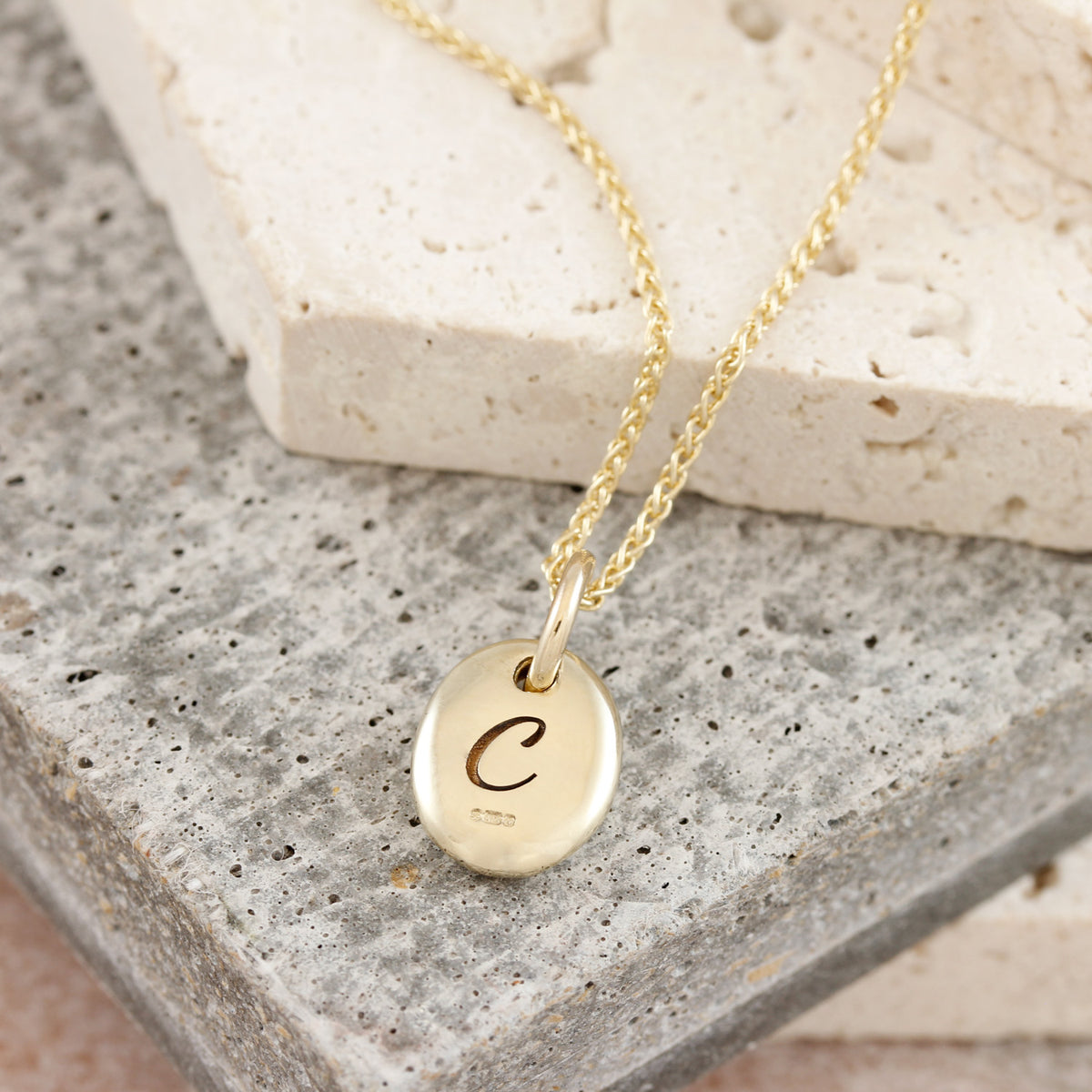 solid gold pebble necklace engraved with inital