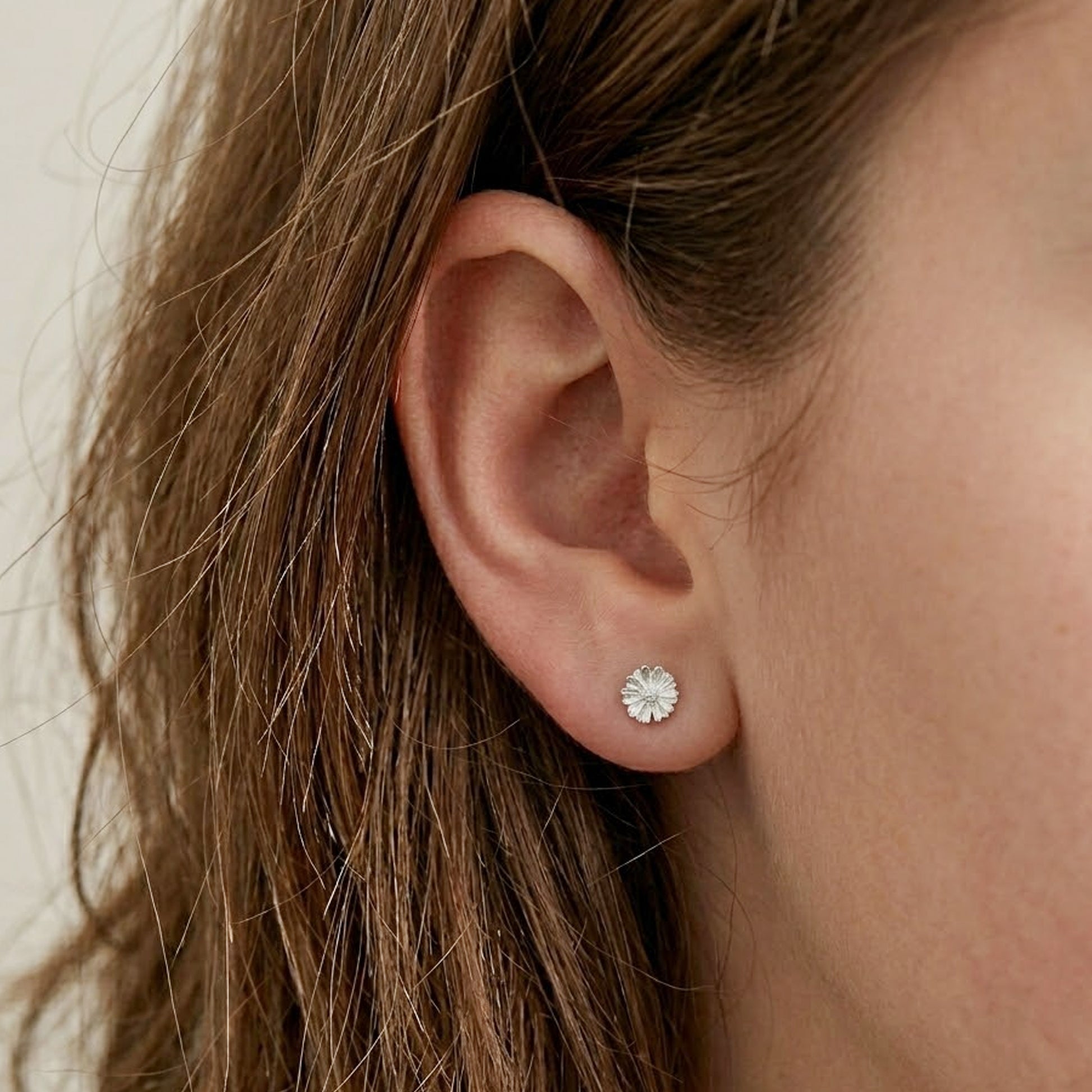 small daisy flower stud earrings on model