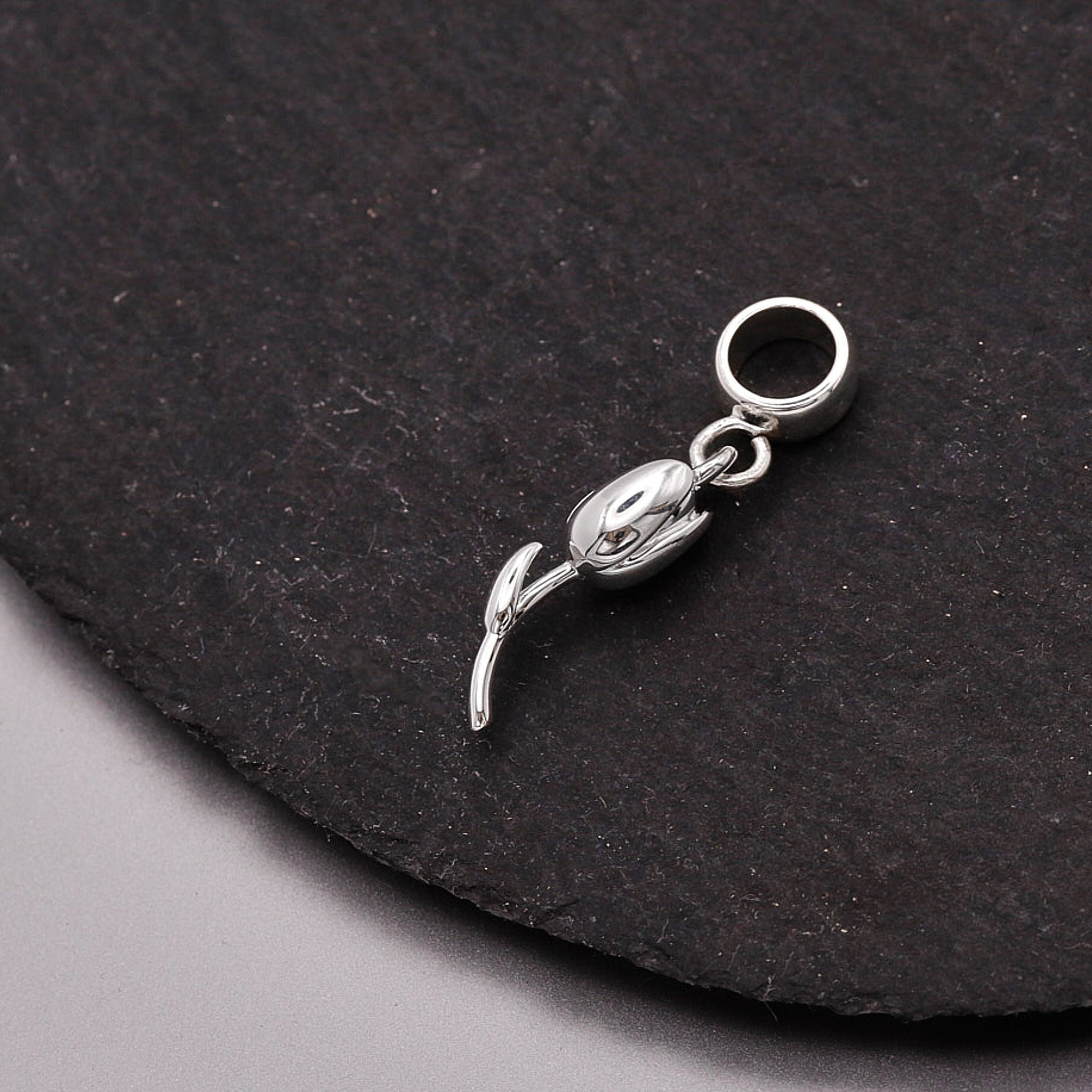 Silver tulip flower on a dark stone surface