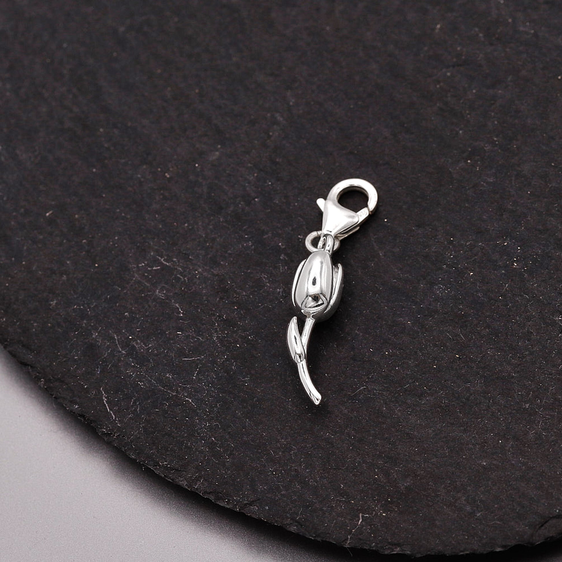Silver tulip flower harm with a lobster clasp on a black background