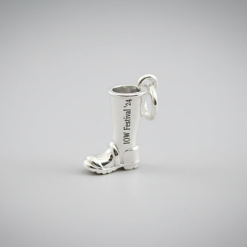 Silver boot charm on a grey surface