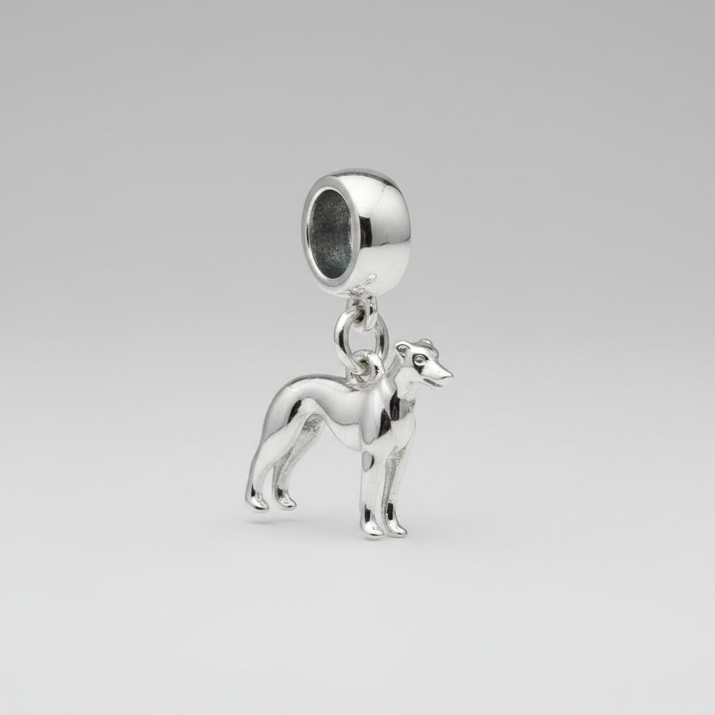 Silver dog-shaped charm on a grey surface