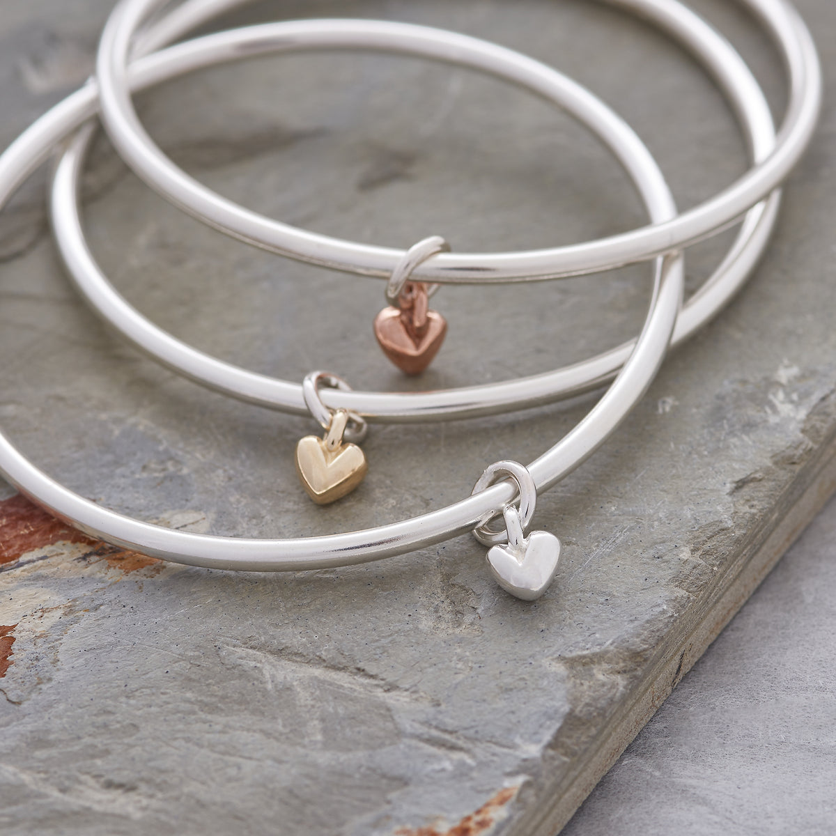unique silver &amp; gold heart charm bangles made in the UK from recycled silver